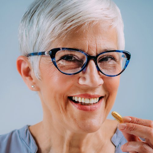 Frau hält eine Kapsel in der Hand